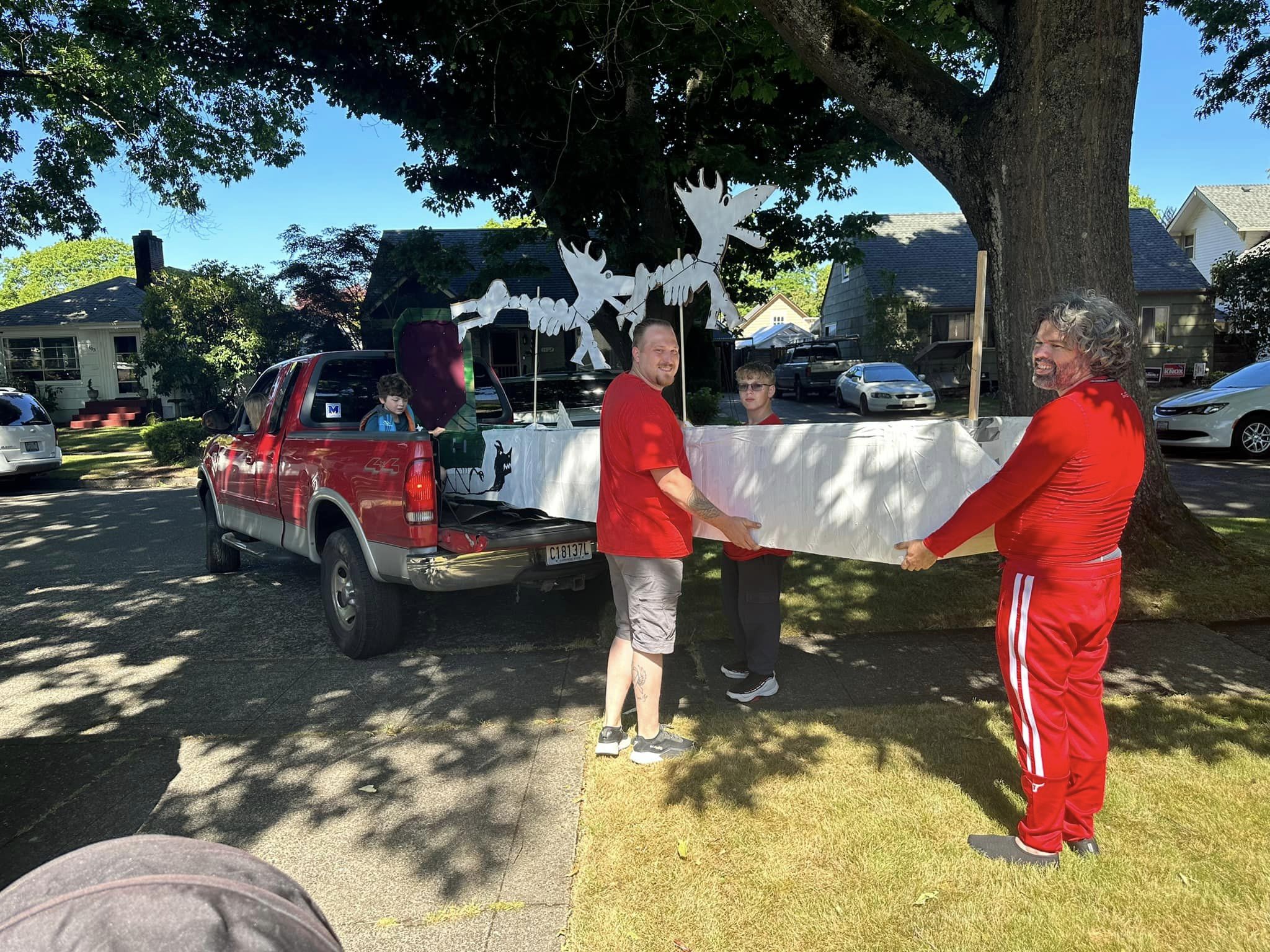 2023-07-02-cardboard-boat-walking-it-behind-truck.jpg